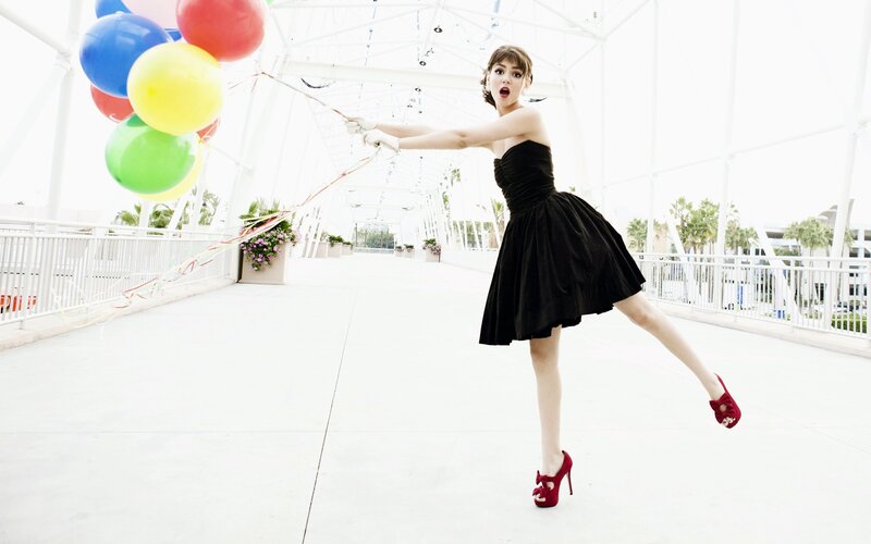 Woman with balloons on a bridge