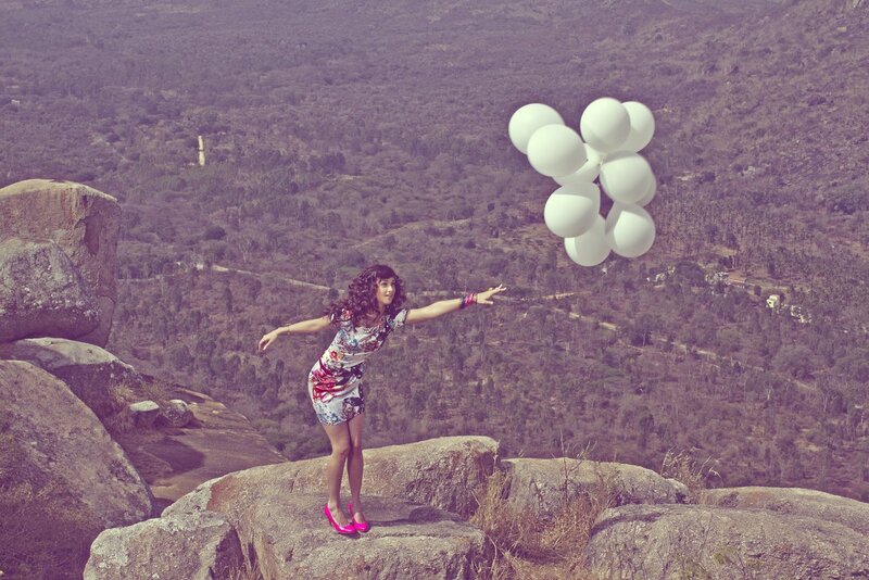 Woman with balloons on a cliff