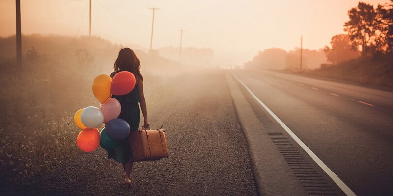 woman with balloons on a road