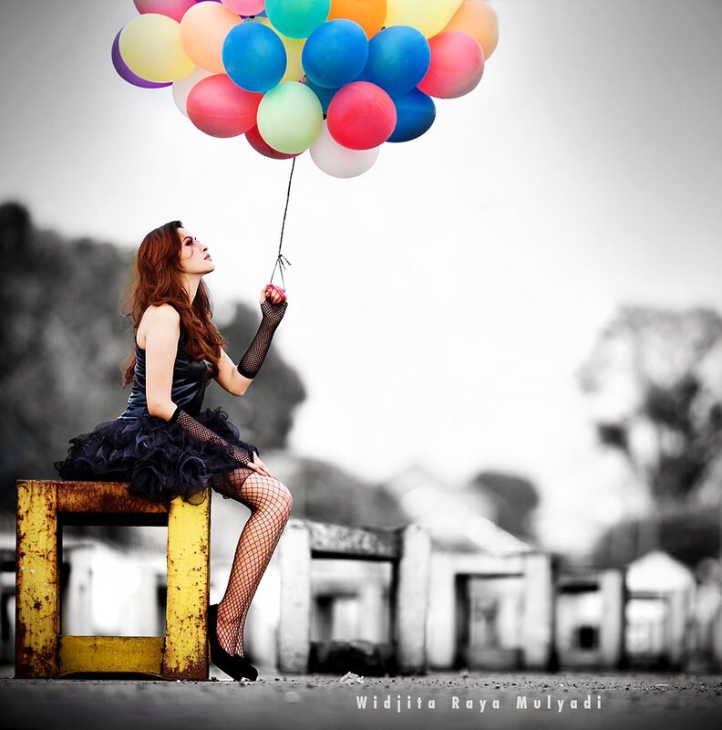 woman with balloons on bench