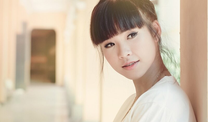 woman with bangs leaning against wall