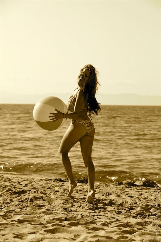 Woman with beach ball on shore