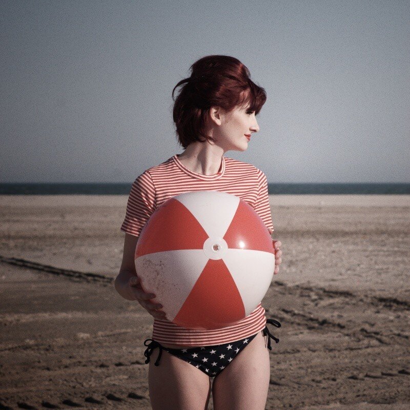 Woman with beach ball on shore
