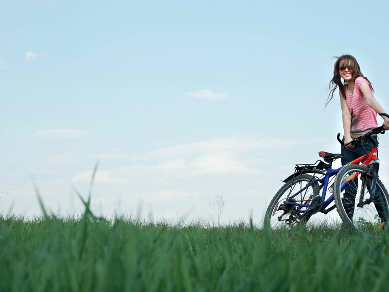 Woman with bicycle in field