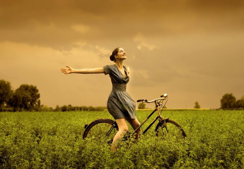 Woman with bicycle in field