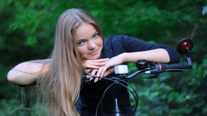woman with bicycle in forest