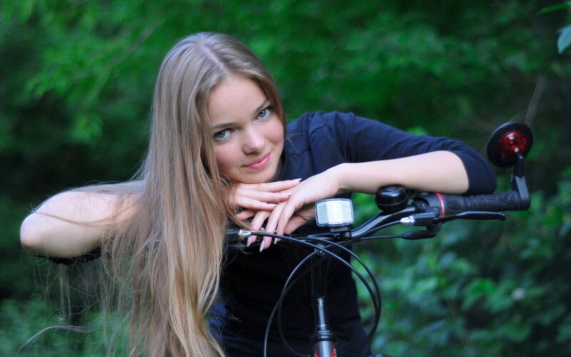 woman with bicycle in forest