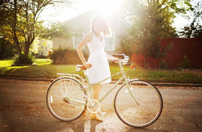 Woman with bicycle in sunlight