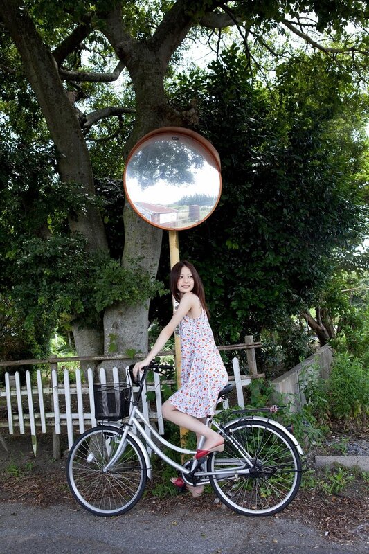 Woman with bicycle near mirror