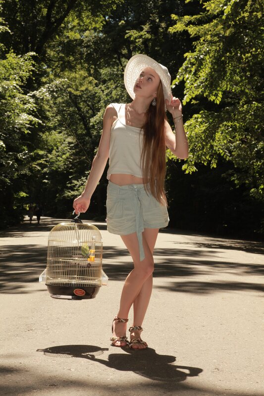 Woman with birdcage in park