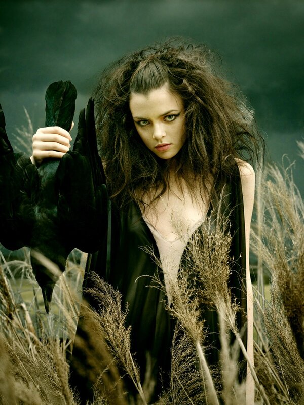 woman with black bird in field