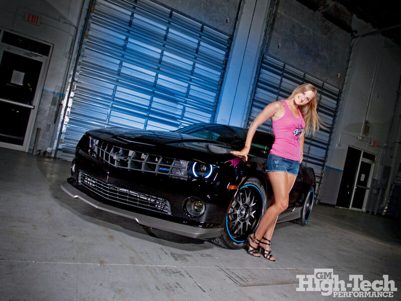 Woman with black Camaro in garage