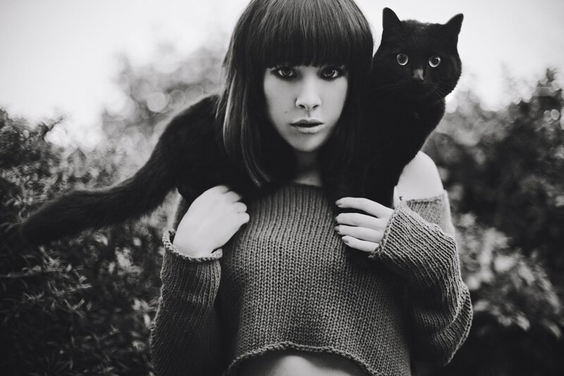 woman with black cat on shoulder