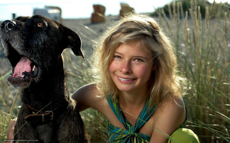 woman with black dog on beach
