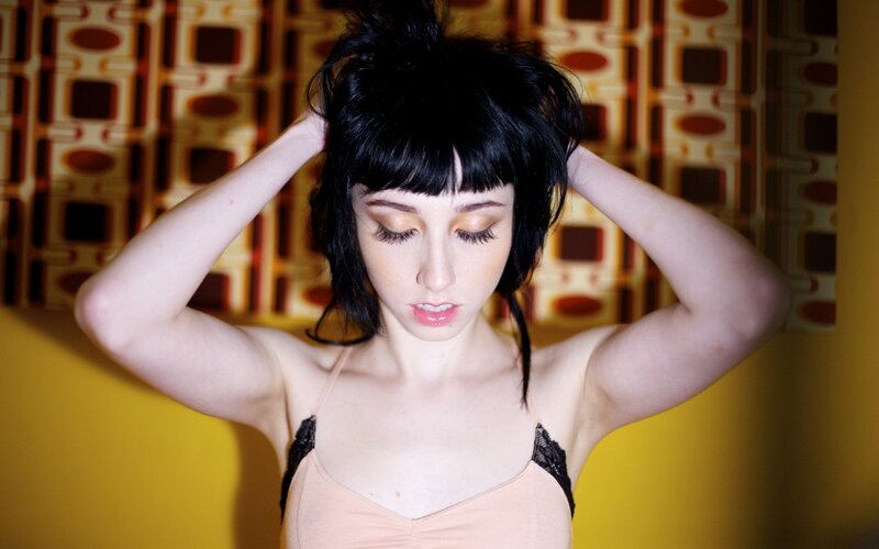 woman with black hair adjusting her hair