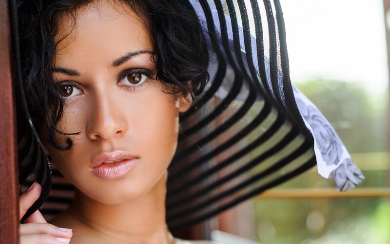 woman with black hat looking at camera