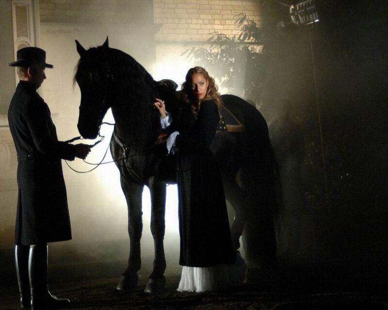 woman with black horse at night