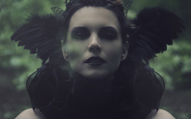 woman with black wings in forest