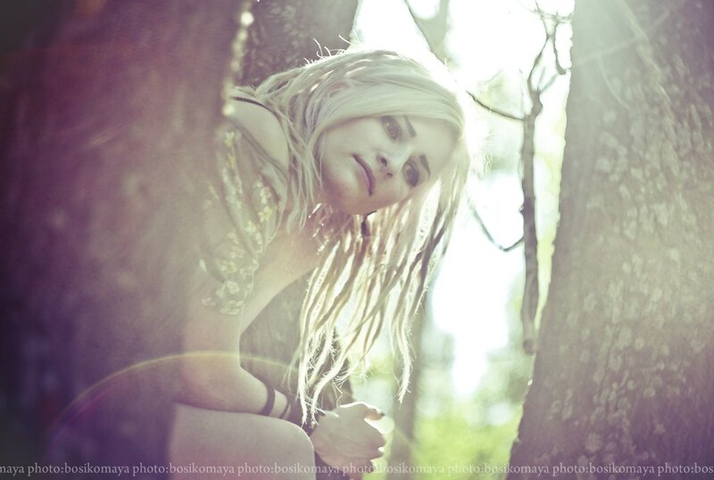 woman with blonde dreadlocks in forest