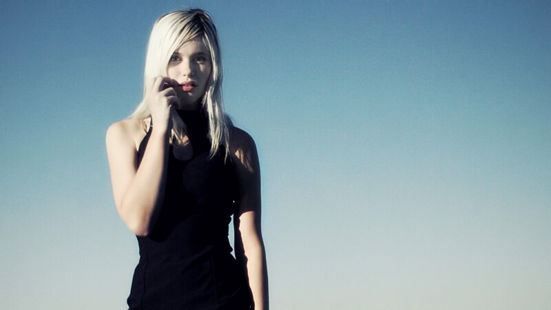 woman with blonde hair against blue sky