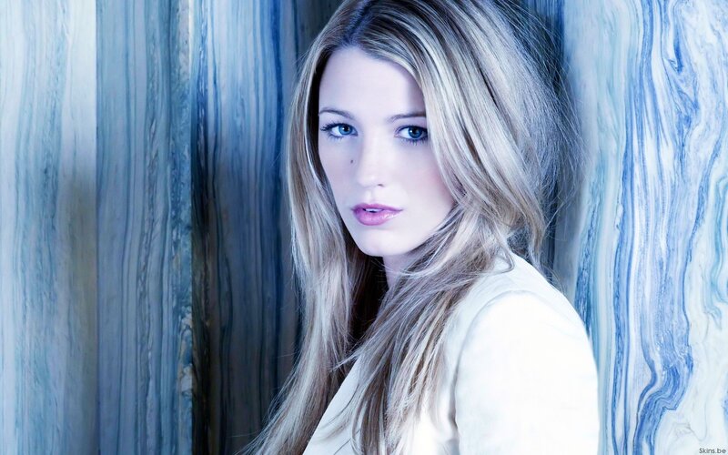 woman with blonde hair against blue wall