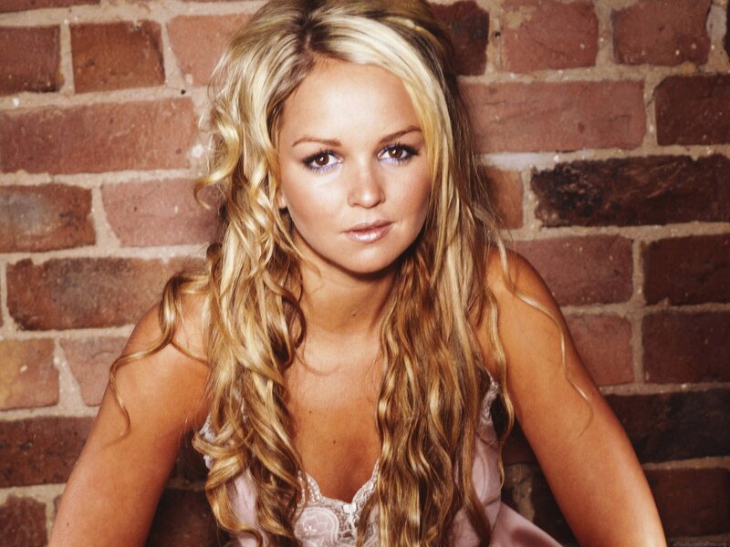 woman with blonde hair against brick wall