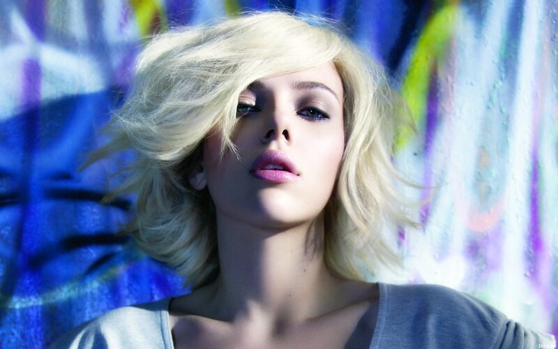 woman with blonde hair against colorful wall
