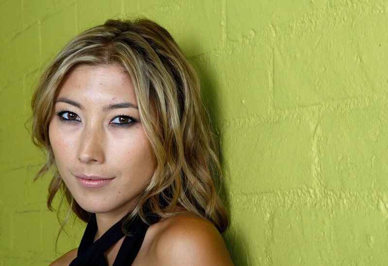 woman with blonde hair against green wall
