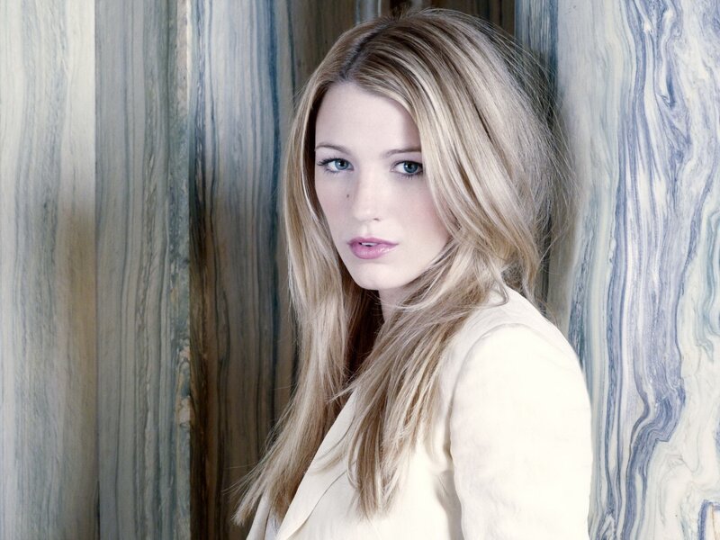 woman with blonde hair against marble wall