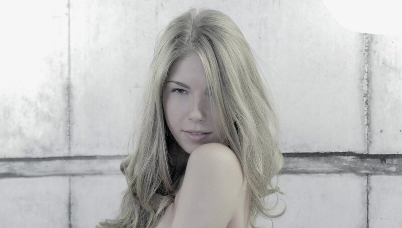 woman with blonde hair against wall