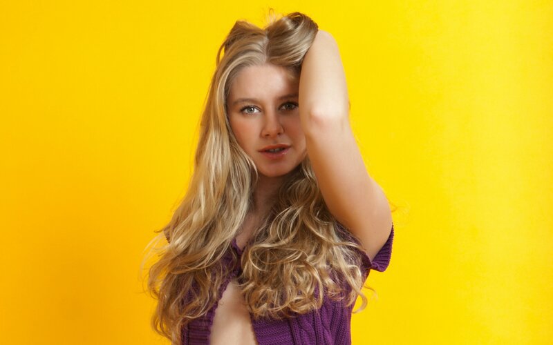woman with blonde hair against yellow