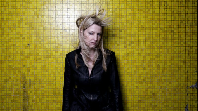 Woman with blonde hair against yellow tiles