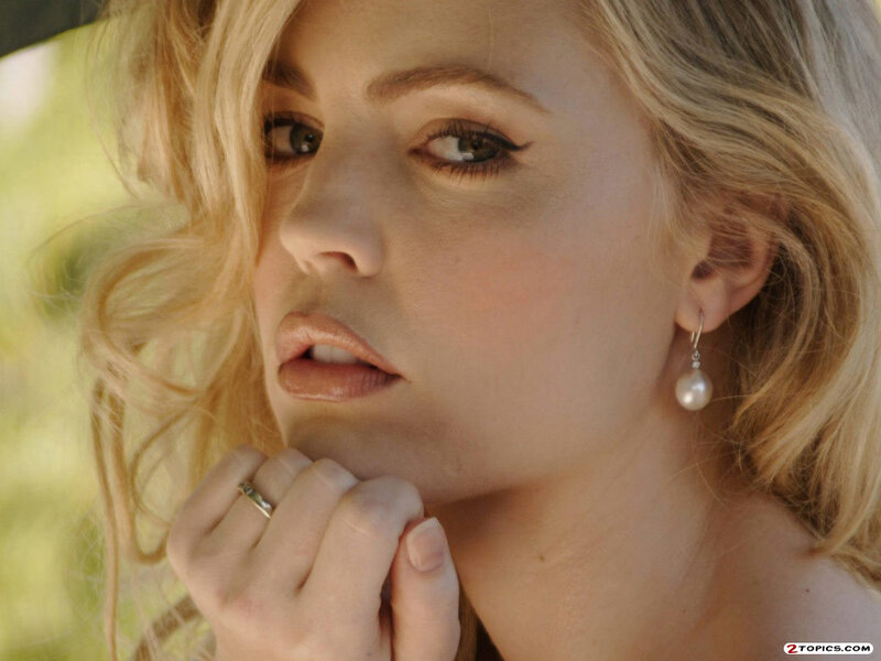 woman with blonde hair and pearl earrings