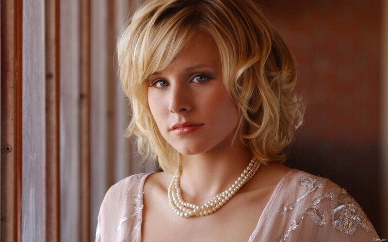 woman with blonde hair and pearls