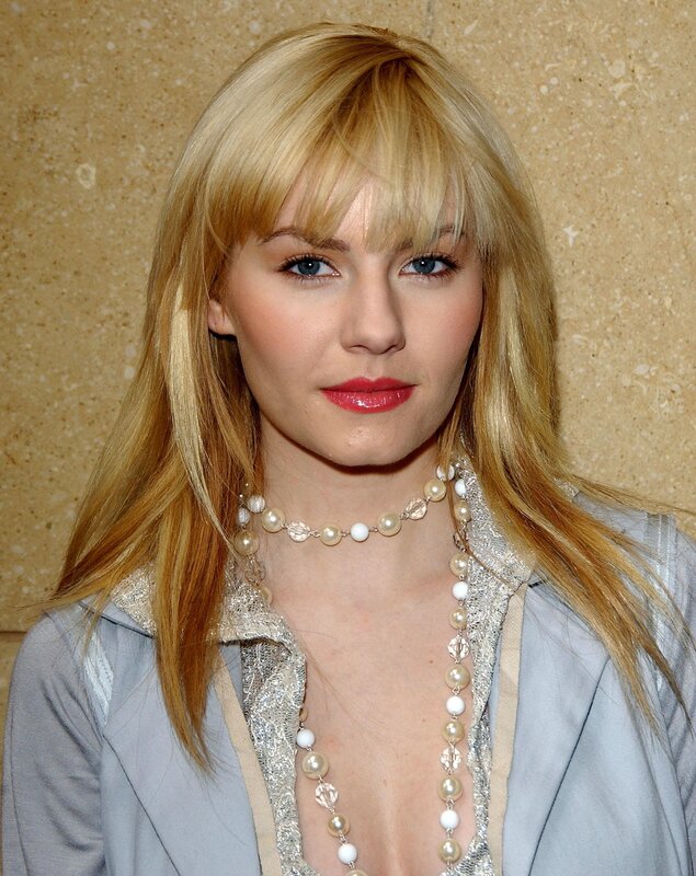woman with blonde hair and pearls