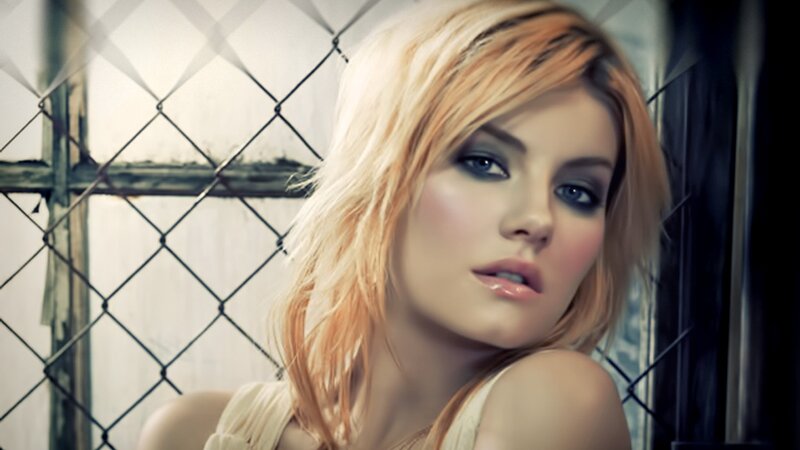 woman with blonde hair behind fence