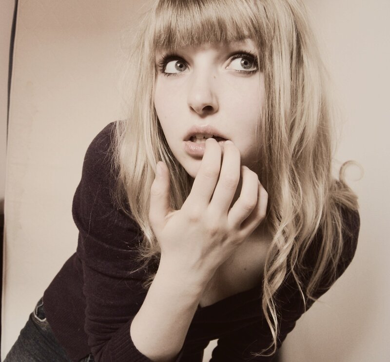 woman with blonde hair biting finger