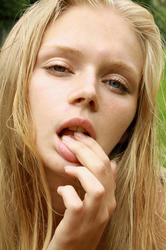 woman with blonde hair biting finger