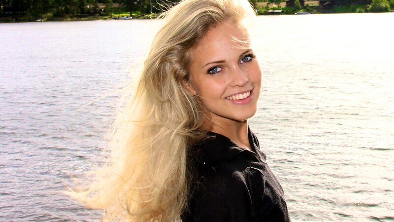 woman with blonde hair by the lake