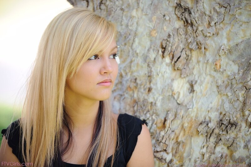 woman with blonde hair by tree