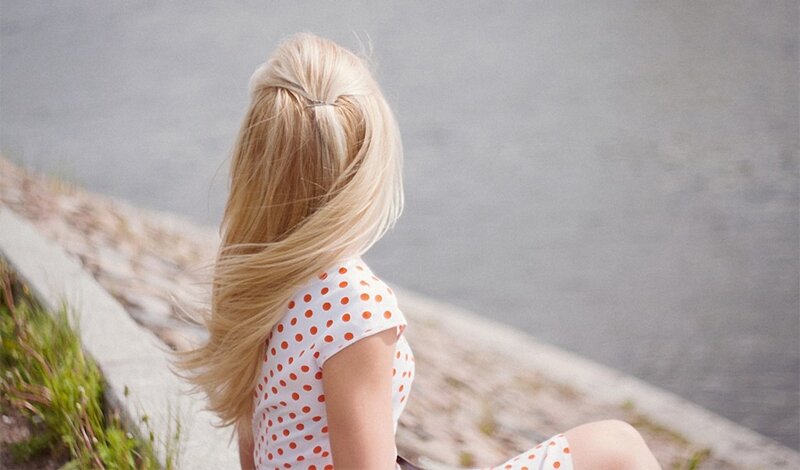 woman with blonde hair by water