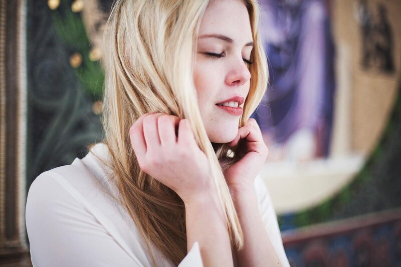 woman with blonde hair closing eyes