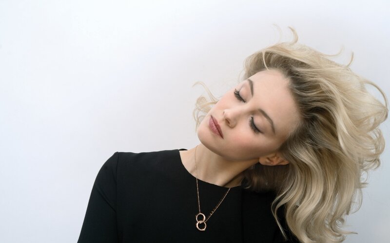 woman with blonde hair closing eyes