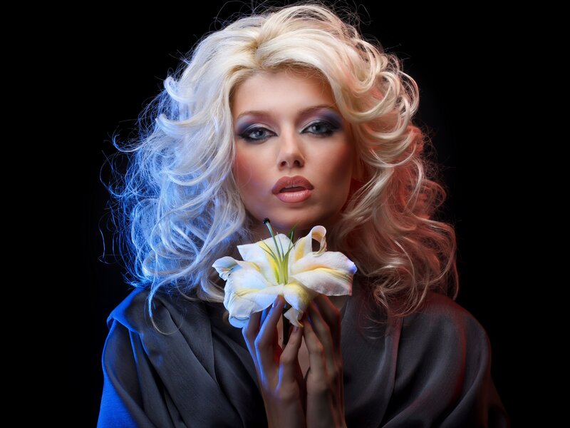 woman with blonde hair holding a flower