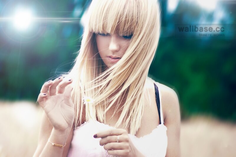 woman with blonde hair holding flower