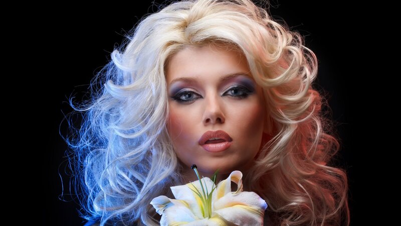 woman with blonde hair holding flower