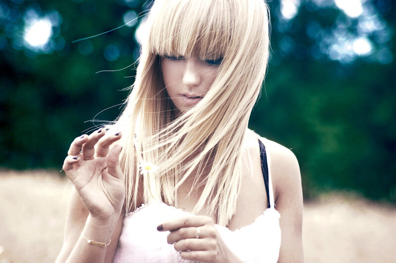 woman with blonde hair holding flower