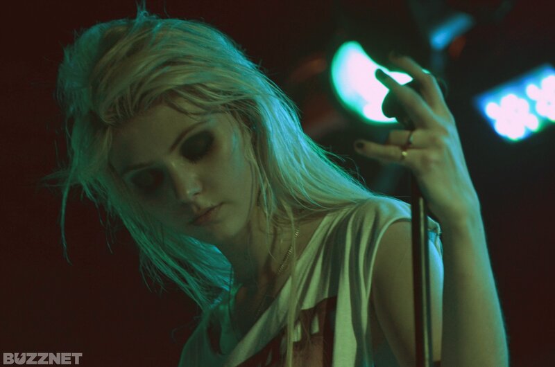 woman with blonde hair holding microphone