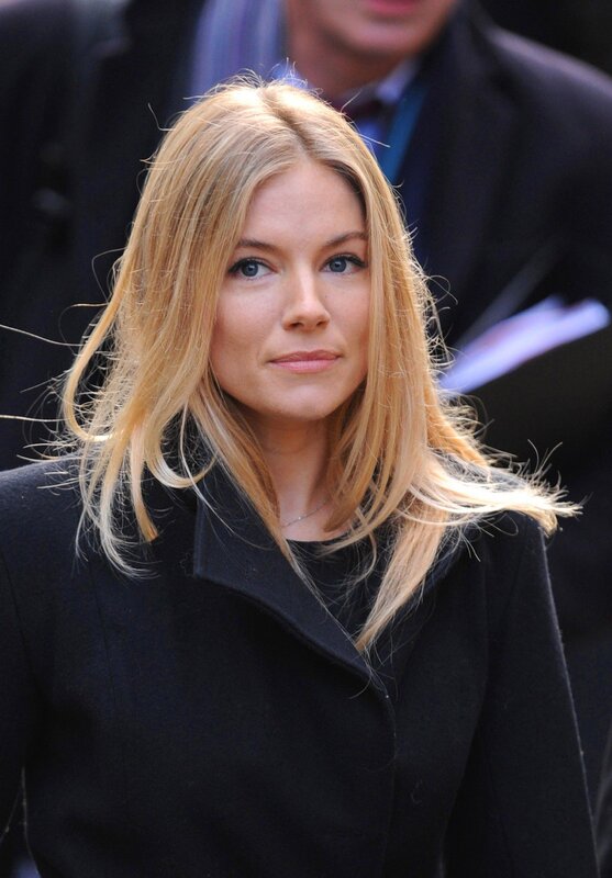 woman with blonde hair in black coat