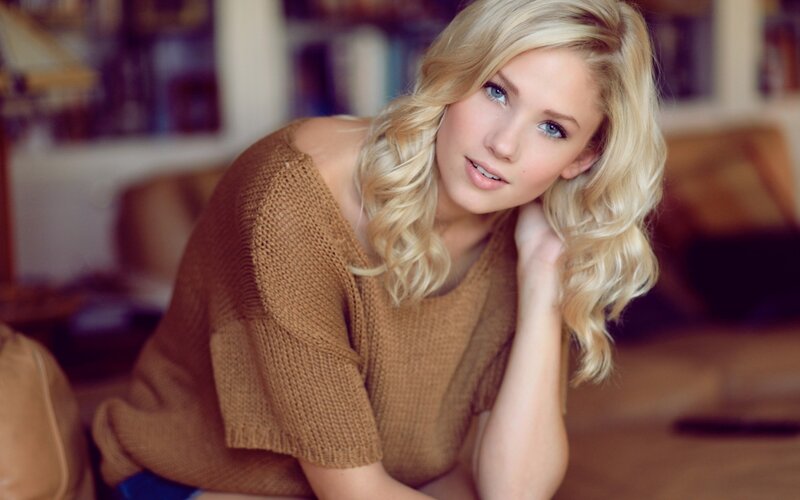 woman with blonde hair in brown sweater